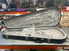 Load image into Gallery viewer, Open hardshell tear drop electric guitar case with plush interior lining and metal latches on a workbench